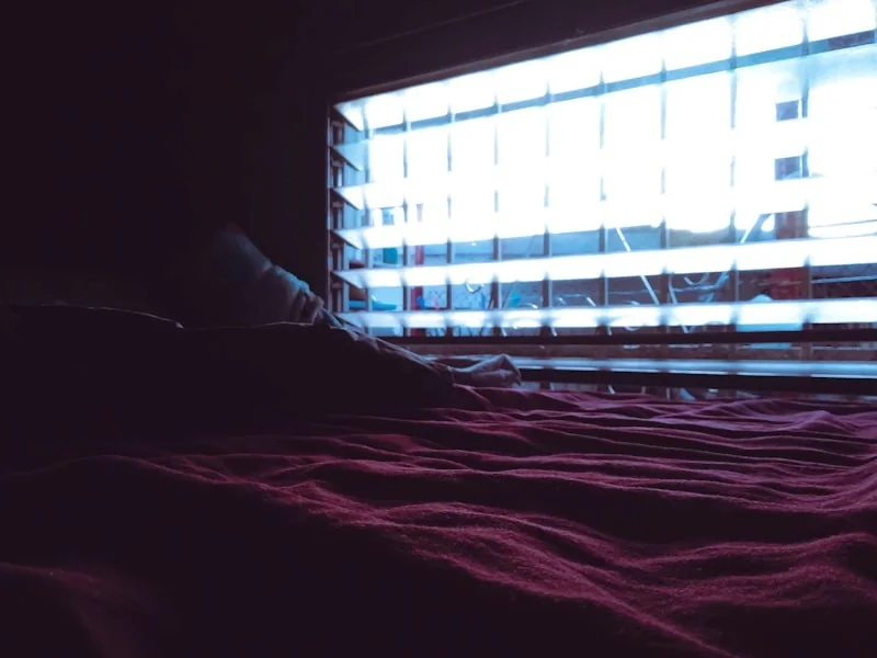 A darkened room with faint light spilling through a doorway.